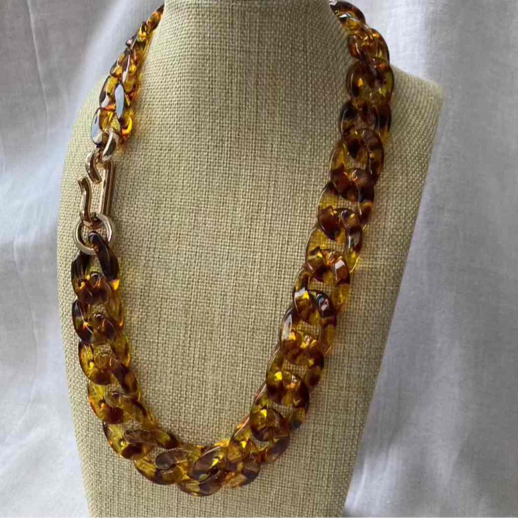 Brown leopard necklace on a mannequin bust against a neutral background