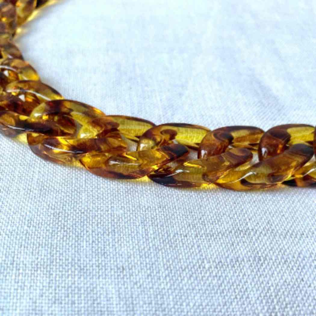 Brown braided necklace on a white fabric background