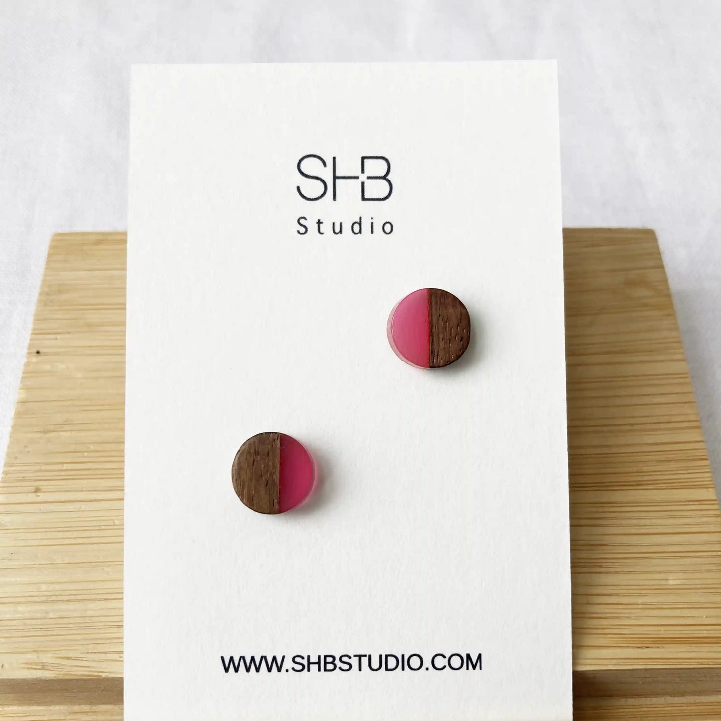Half Wooden and half dark shiny pink colour resin earrings on a SHB Studio card.