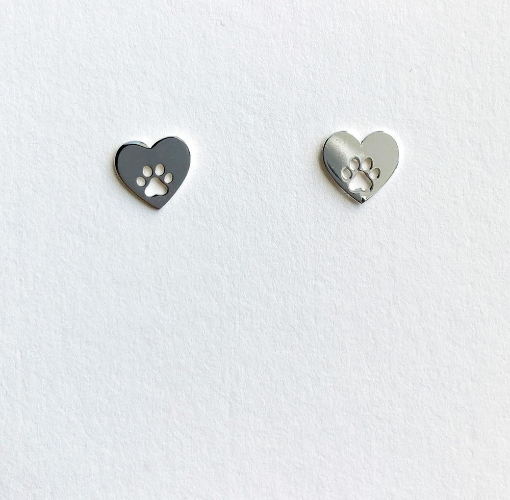 A pair of sterling silver heart and paw stud earrings placed on a white card.