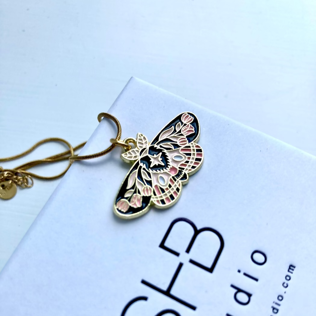 Butterfly-shaped pendant on a white card with text