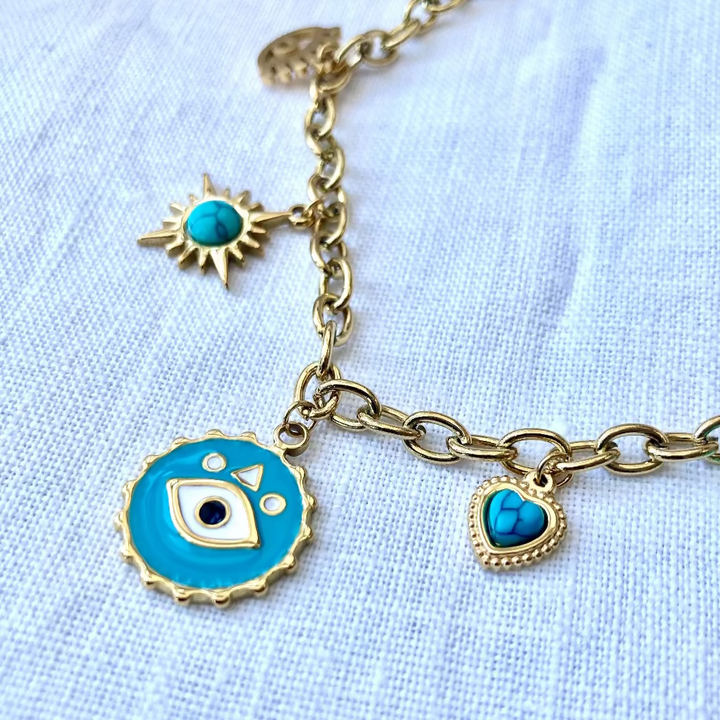 A gold-plated stainless steel necklace with a chain link, featuring a charm with an evil eye design and turquoise accents.