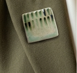 square ceramic green brooch on green fabric
