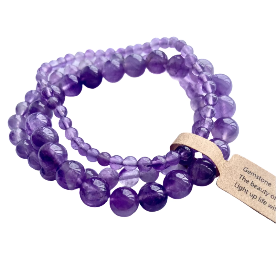 Purple beaded bracelet with a wooden tag on a light purple background