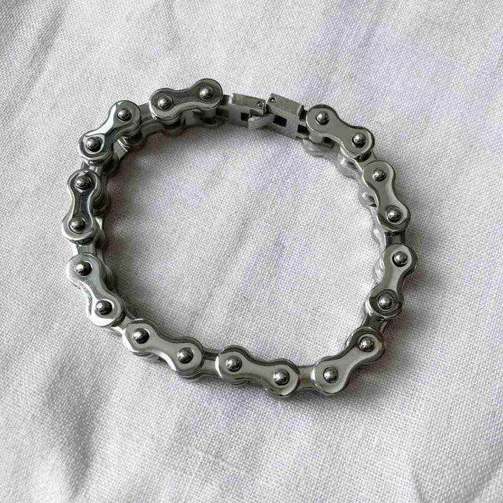 Bracelet made of interlocking metal rings on a white fabric background