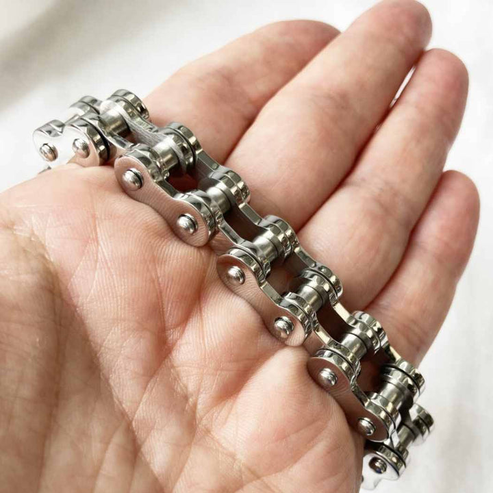 silver colour chain bracelet on a hand against a white background