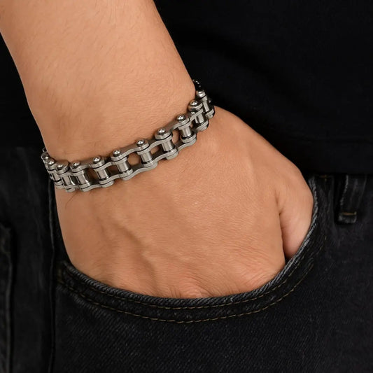 Silver chain bracelet on a wrist with a black background