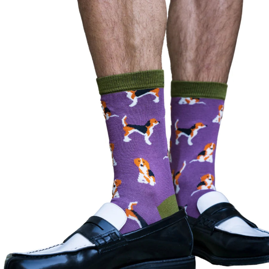 Purple socks with dog pattern worn with black shoes on a white background