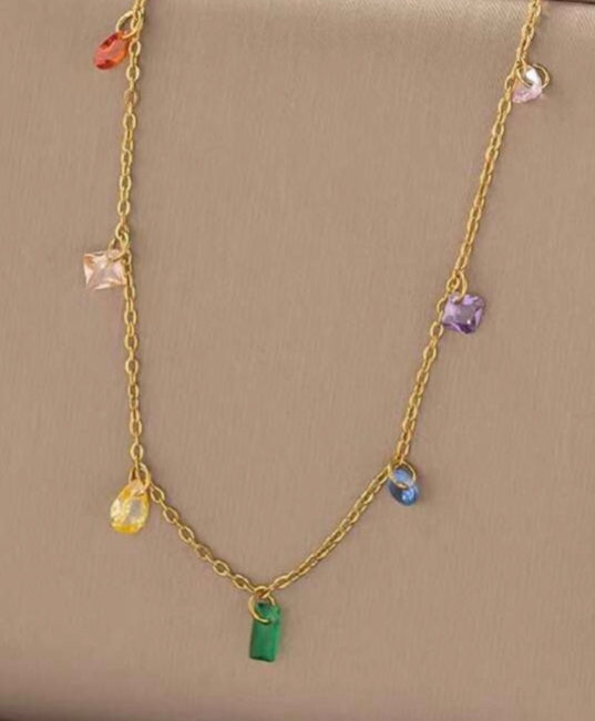 Gold necklace with colorful beads on a beige display box