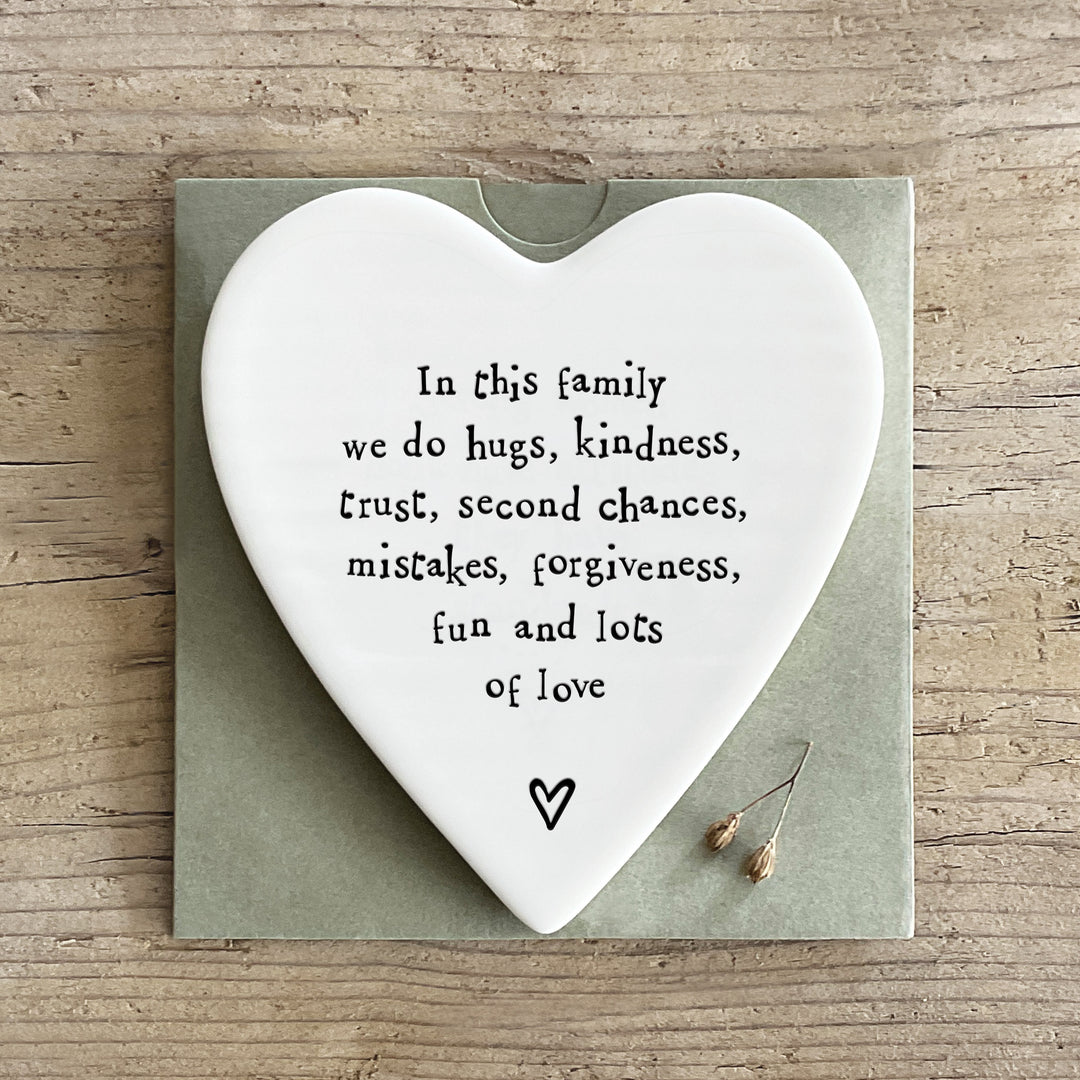 Heart-shaped porcelain plaque with family values text on a wooden surface