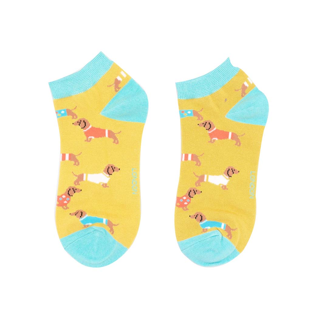 Pair of yellow socks with dog pattern and blue accents on a white background