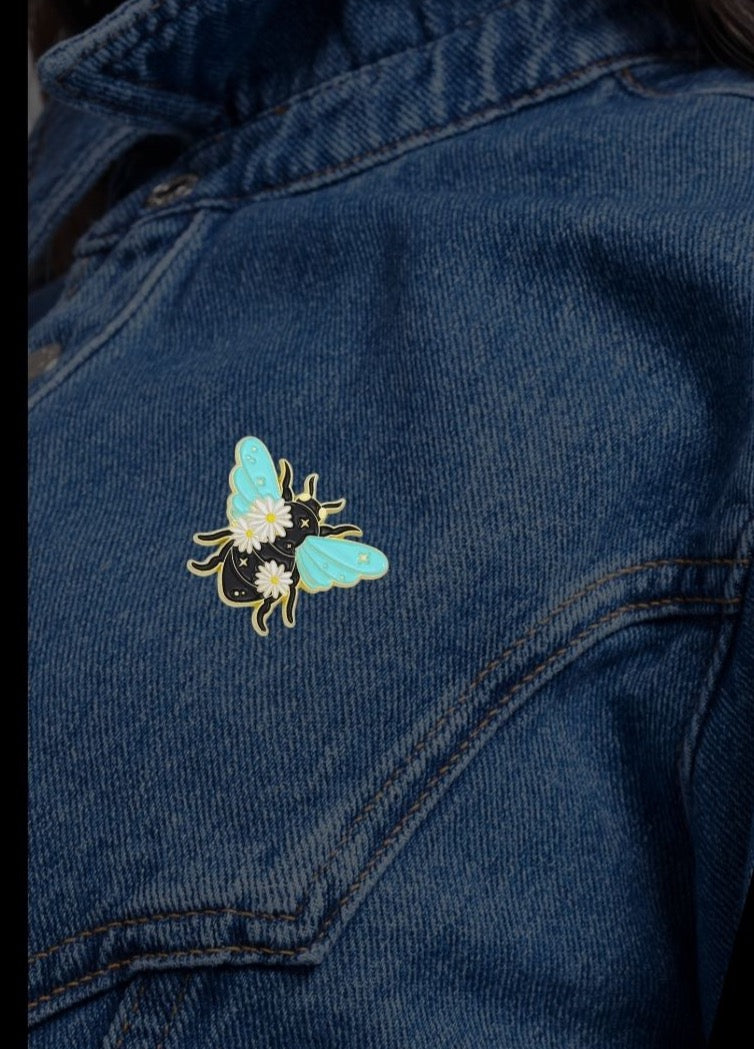Mint and gold celestial bee enamel pin with daisies and stars on a black body — small meaningful gift from SHB Studio.1