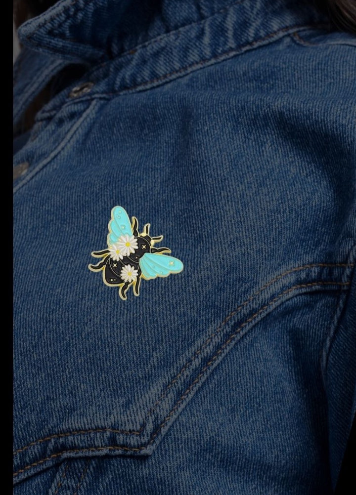 Mint and gold celestial bee enamel pin with daisies and stars on a black body — small meaningful gift from SHB Studio.1