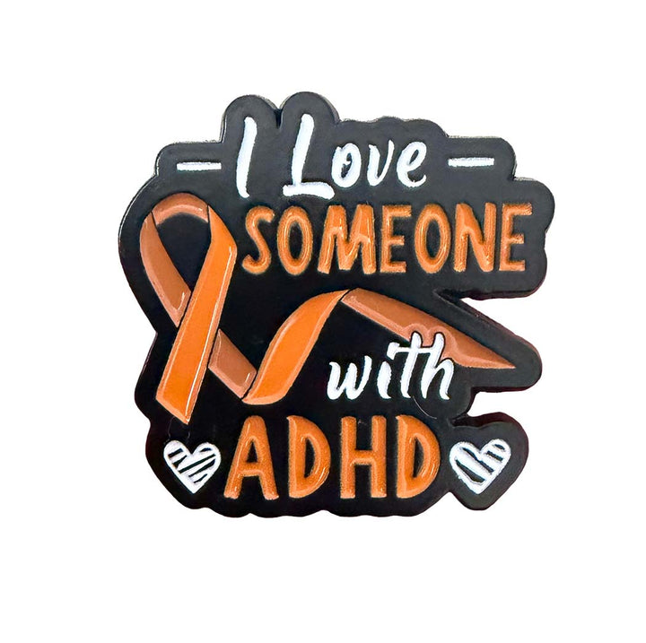 An enamel pin with a black background and an orange awareness ribbon, featuring the text &