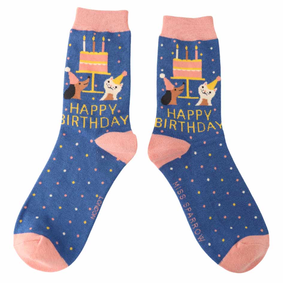Pair of blue socks with birthday cake and cat designs on a white background