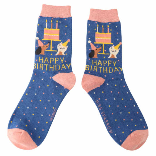 Pair of blue socks with birthday cake and cat designs on a white background