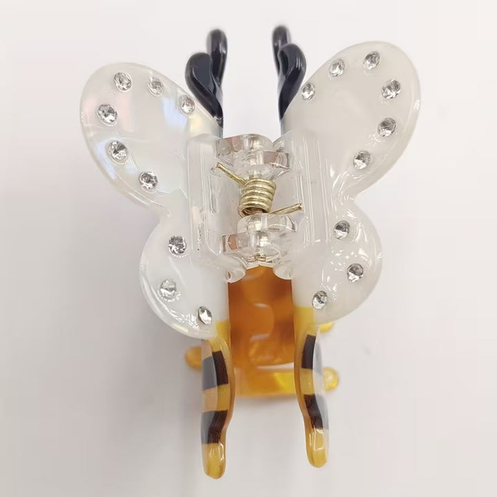 bee shaped hair clip with clear wings and yellow body on a white background