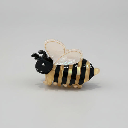 bee-shaped hair clip with black and yellow stripes on a gray background