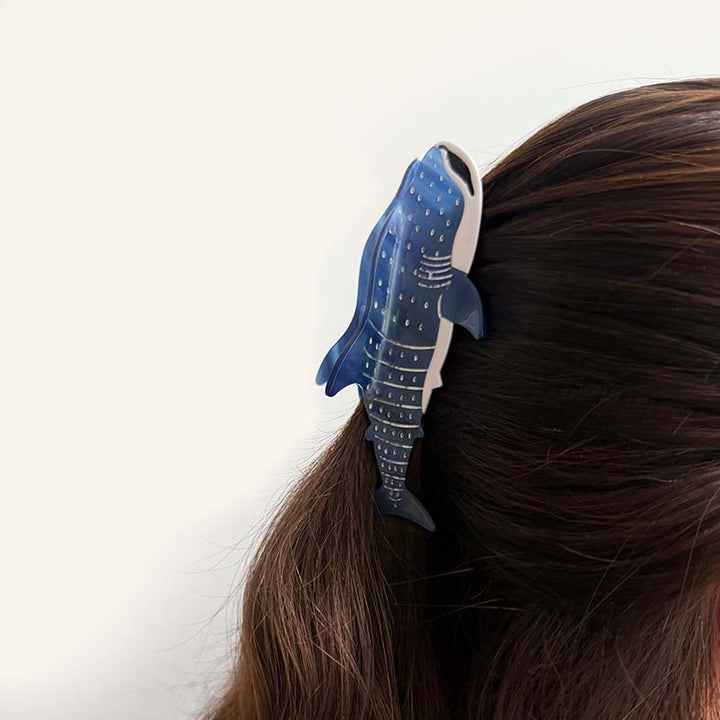 Blue whale-shaped hair clip on a person&