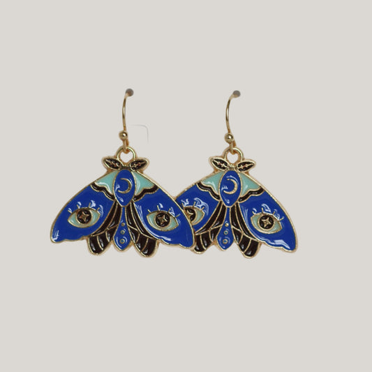 Blue and black moth-shaped earrings on a light gray background