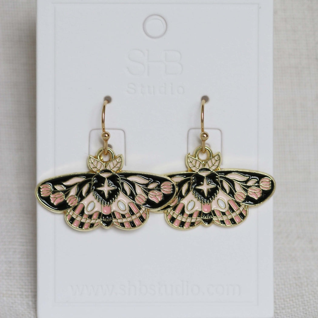 Butterfly-shaped earrings on a white card with &