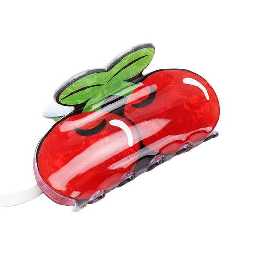 Red cherry-shaped hair clip with a green leaf on a white background