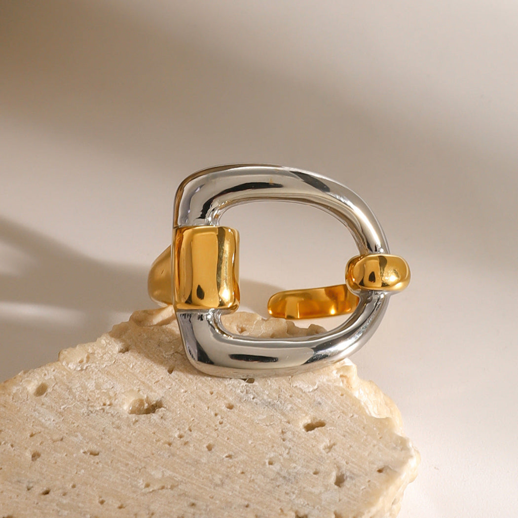 Gold and silver ring on a beige stone surface