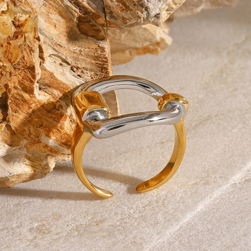 Gold and silver ring on a textured stone surface