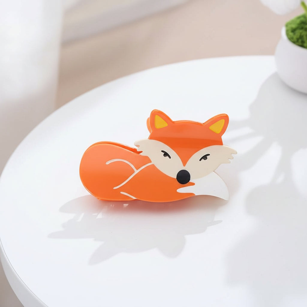 Fox-shaped hair claw stand on a textured surface with decorative elements in the background 