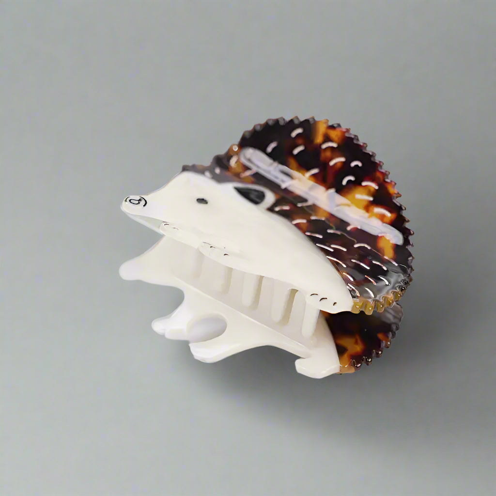 Hedgehog-shaped hair clip with tortoiseshell pattern on a white surface