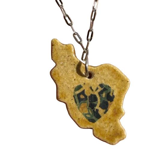 Ceramic pendant iran map middle print of heart design on a chain held in hand