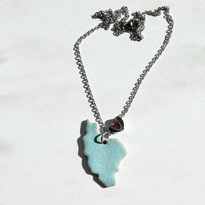 Necklace with a blue  iran map pendant on a white background