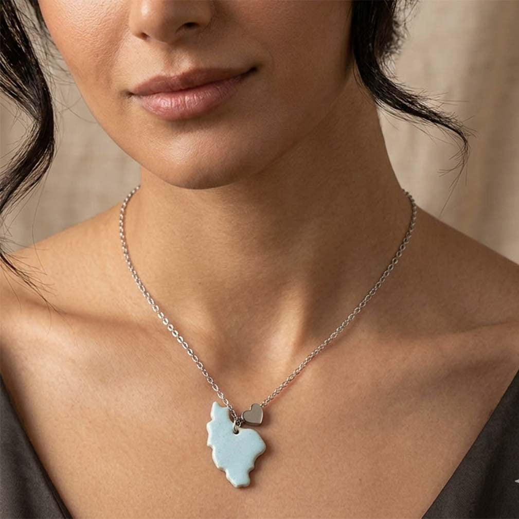Necklace with a blue pendant worn by a person against a neutral background