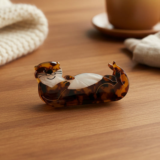 Tortoiseshell otter-shaped hair claw on table.