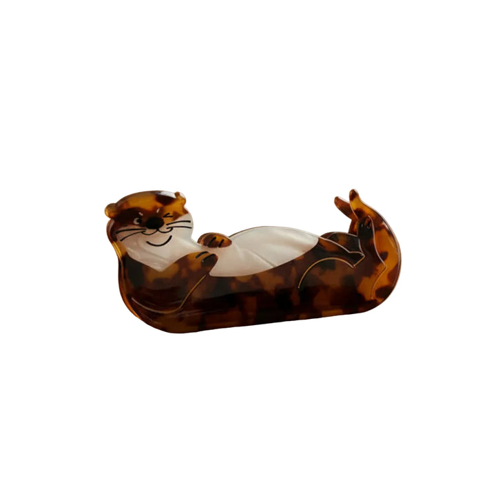 Tortoiseshell otter-shaped hair claw on table.