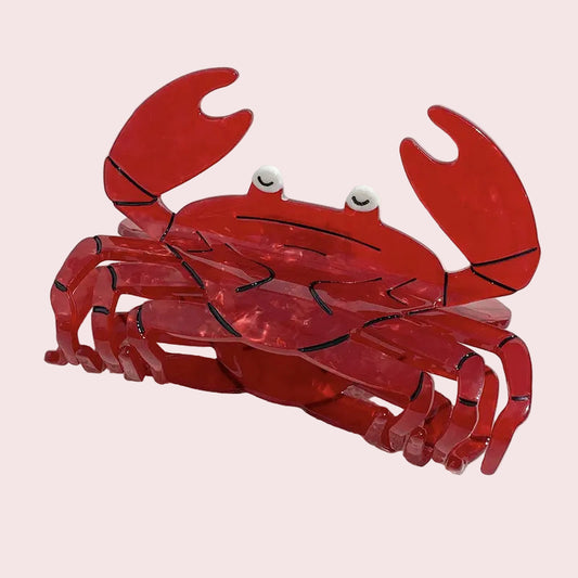 Red crab-shaped object on a white sandy background