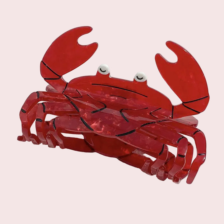 Red crab-shaped object on a white sandy background