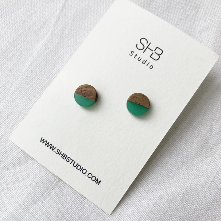 Half Wooden and half light green resin earrings on a SHB Studio card.