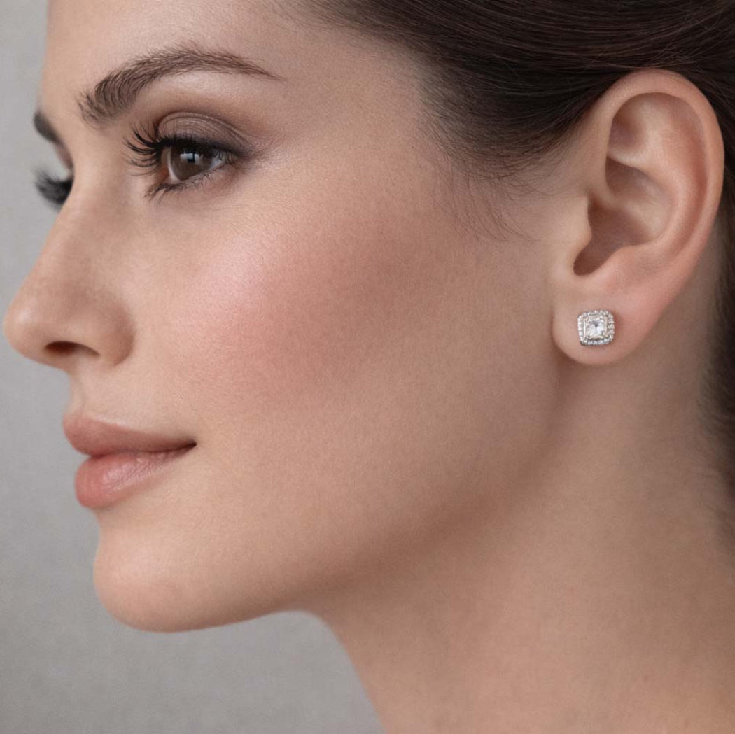 Close-up of a woman wearing a diamond earring against a neutral background