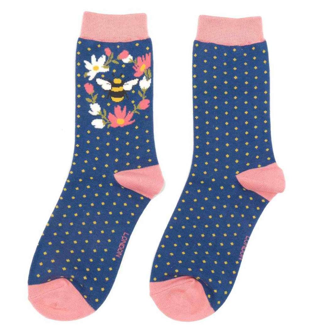 Pair of socks with floral and bee design on a blue background