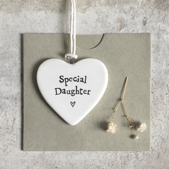 Heart-shaped ceramic tag with 'Special Daughter' text on a gray background