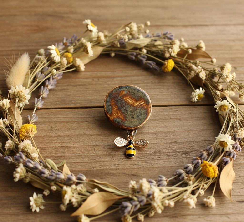 Jewelry brooch with a bee design on a white background, featuring the SHB Studio logo.