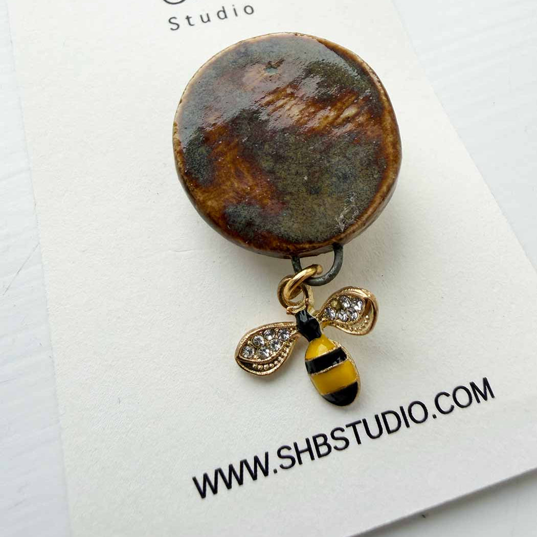 brooch with bee charm on a branded card