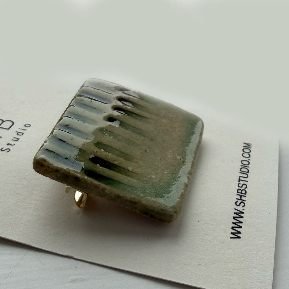Square ceramic ring with textured surface on a white card with 'SH Studio' branding.