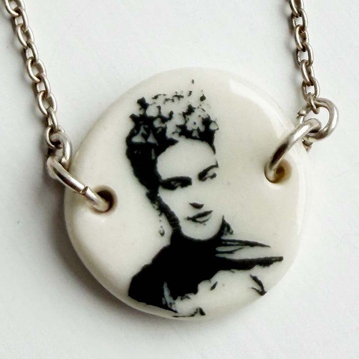 Necklace with a pendant featuring a black and white portrait Frida Kahlo Mexican painter on a white background