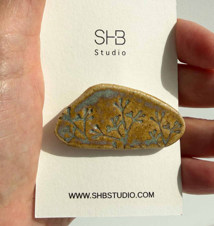 Ceramic brooch with floral design held on a SHB Studio card