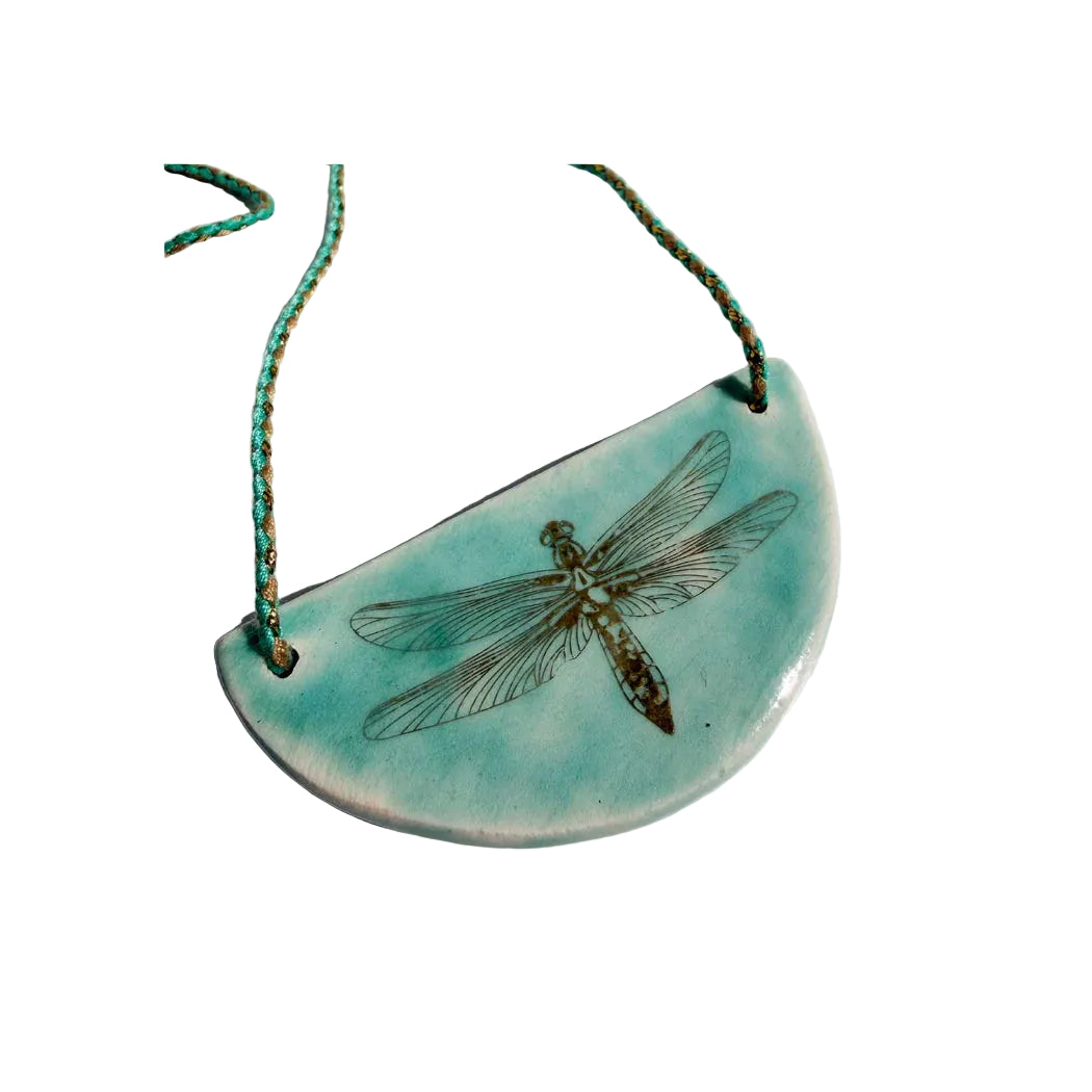 Turquoise necklace with a dragonfly design on a white background