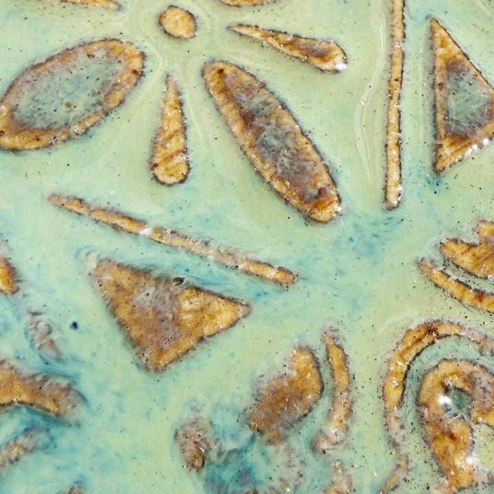 Close-up of ceramic tiles with gold and green glaze patterns
