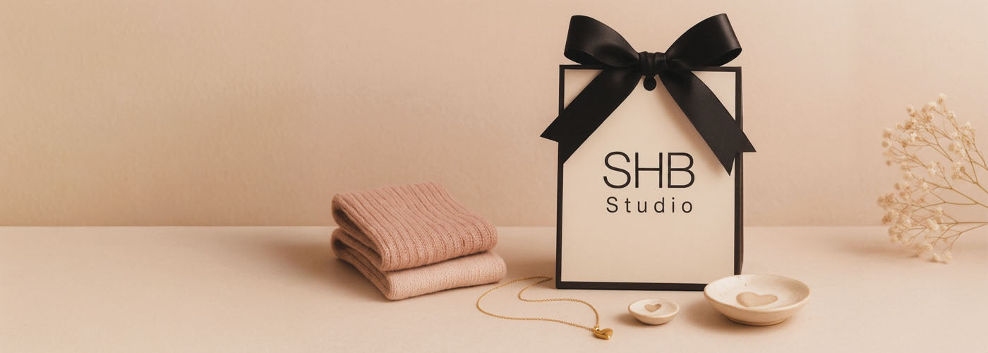 SHB studio gift bag with black ribbon and 'SHB Studio' logo on a beige background