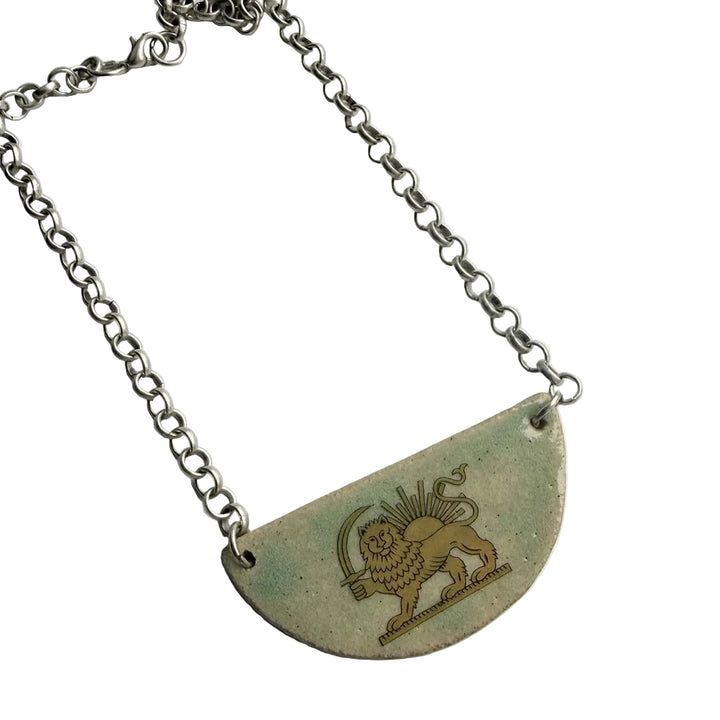 Necklace with a semi-circular pendant featuring a lion and sun persian heritage on a white background